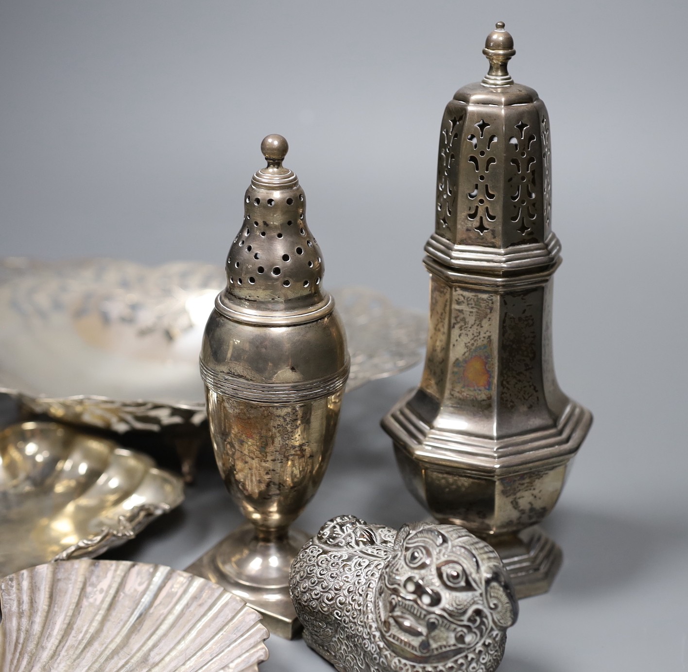Mixed silver and white metal items including two silver casters, a silver mounted hand mirror, an Egyptian pierced dish, two small dishes and a lion box and cover.